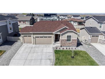 Beautiful one-story home boasting a three-car garage and well-manicured front yard at 10553 Xenia Ct, Commerce City, CO 80640