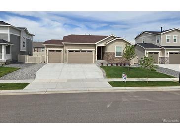 Charming single-story home with well-manicured lawn, three-car garage, and welcoming curb appeal at 10553 Xenia Ct, Commerce City, CO 80640
