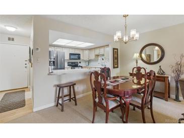 Inviting dining area featuring a chandelier, and a seamless connection to the modern kitchen at 13631 E Marina Dr # 502, Aurora, CO 80014