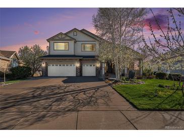 Charming two-story home featuring a three car garage, stone accents, and manicured lawn at 26861 E Clifton Dr, Aurora, CO 80016