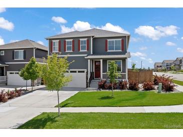Charming two-story home featuring a well-manicured lawn, red shutters, and an attached two-car garage at 14100 Shasta Daisy St, Parker, CO 80134