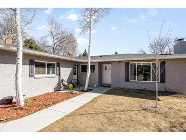 Charming single story home showcasing a gray brick facade and well maintained front yard at 2360 Estes St, Lakewood, CO 80215