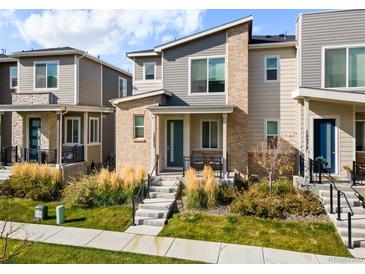 Charming townhouse with a modern design, showcasing a brick facade and well-maintained front yard landscaping at 12273 Karls Ln, Northglenn, CO 80241