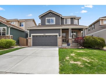 Charming two-story home with a gray facade, well-maintained lawn, and a convenient two-car garage at 16164 E Hinsdale Ave, Aurora, CO 80016