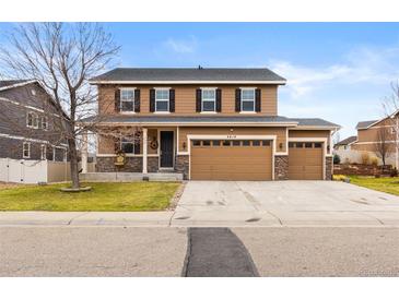Charming two-story home featuring a three-car garage and a covered front porch at 4814 Monarch Dr, Firestone, CO 80504