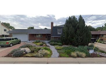 Charming brick home featuring a landscaped front yard, brick walkway, and attached garage at 10902 Bannock St, Northglenn, CO 80234