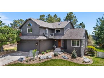 Beautiful two-story home with gray siding, brick accents, mature landscaping, and a well-maintained front yard at 6275 Ponderosa Way, Parker, CO 80134