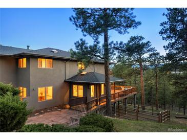 Stunning home featuring a large deck, nestled among mature trees, offering breathtaking views at 28890 Pinewood Vista Dr, Evergreen, CO 80439