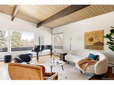 Bright living room featuring hardwood floors, high ceilings, and large windows with an elegant grand piano at 5200 W Ottawa Ave, Littleton, CO 80128