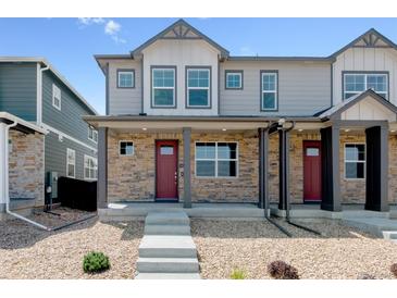 Charming townhouse with stone accents, a covered porch, and a striking red front door at 22315 E 6Th Ave, Aurora, CO 80018