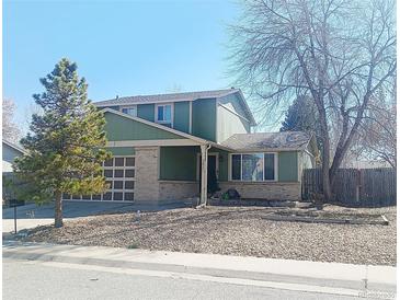 Charming two-story home with a well-manicured lawn and attached garage at 9852 W 76Th Ave, Arvada, CO 80005