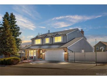 Charming two-story home with a well-maintained lawn, attached garage, and inviting front porch at 4620 Blackhawk Way, Denver, CO 80239