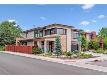 Contemporary home featuring stone accents, manicured landscaping, and a bright red front door at 4274 E Dickenson Pl, Denver, CO 80222