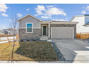 Charming home featuring stone accents, a well-kept lawn, and an attached two-car garage at 4598 Boone Cir, Brighton, CO 80601