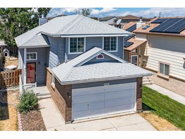 Two-story home with a gray exterior, brick accents, and a two-car garage, offering curb appeal at 8847 Cloverleaf Cir, Parker, CO 80134