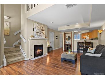 Inviting living room with a cozy fireplace and an open layout to the kitchen area at 1320 S Monaco St Pkwy # 3, Denver, CO 80224