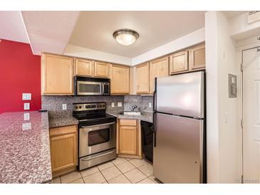 Cozy kitchen featuring stainless steel appliances and light wood cabinets at 1833 N Williams St # 402, Denver, CO 80218