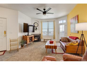 Bright living room featuring a cozy fireplace and a large window for natural light at 5723 N Gibralter Way # 205, Aurora, CO 80019