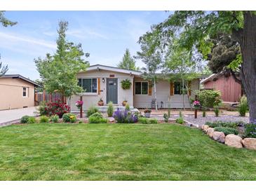 Charming single-story home with a lush, well-manicured front yard and mature trees at 250 W Midway Blvd, Broomfield, CO 80020