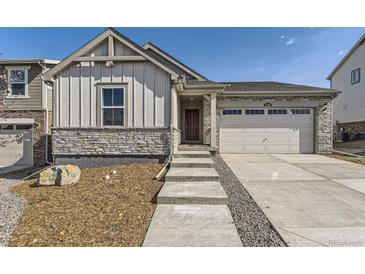 Charming home featuring stone accents, vertical siding, well-maintained landscaping and an attached two-car garage at 22015 E 39Th Ave, Aurora, CO 80019