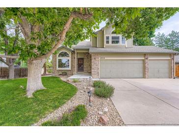 Charming two-story home with a well-maintained lawn, mature trees, and a two-car garage at 4858 S Queen St, Littleton, CO 80127