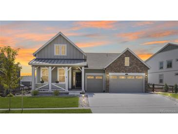 Beautiful two-story home featuring a covered porch, two-car garage, and well-maintained lawn at 5128 Preserve Pl, Firestone, CO 80504