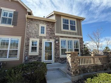 Beautiful two-story townhouse with stone and siding exterior and a cozy front porch at 553 Hanging Rock Pl, Castle Rock, CO 80108