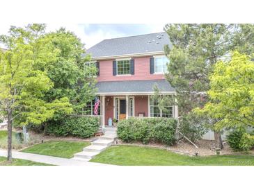Charming two-story home with a covered porch and well-manicured lawn at 8367 Devinney St, Arvada, CO 80005