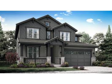 Charming two-story home with dark gray siding, stone accents, and a two-car garage at 7396 S Yank Ct, Littleton, CO 80127
