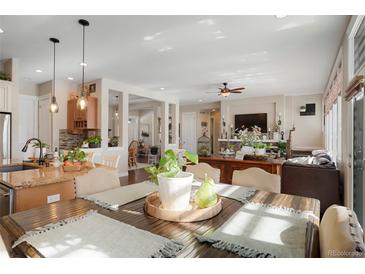 Well-lit dining room with hardwood table, decor, and an open layout to the kitchen and living room at 7186 Weaver Cir, Castle Rock, CO 80104