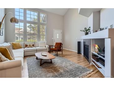 Bright living room with large windows, vaulted ceilings, modern fireplace, and stylish contemporary furnishings at 8300 Fairmount Dr # Aa102, Denver, CO 80247