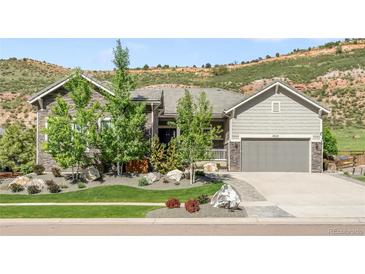 Beautiful single Gathering home boasts stone and siding details, landscaped front yard, and attached garage at 4868 Hogback Ridge Rd, Morrison, CO 80465