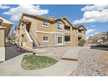 Inviting condo exterior with stone accents, landscaped grounds, and well-maintained walkway at 4730 Copeland Cir # 203, Highlands Ranch, CO 80126