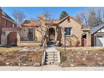 Charming brick home with a tile roof, inviting entrance, and well-maintained landscaping at 1965 Jasmine St, Denver, CO 80220