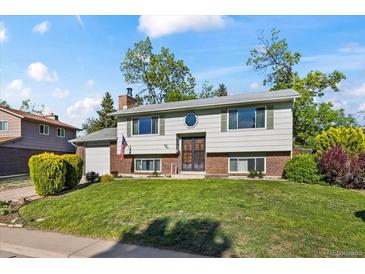 Charming two-story home with a well-manicured lawn, brick accents, and mature trees at 9430 Osceola St, Westminster, CO 80031