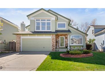 Charming two-story home with a well-manicured lawn, stone accents, and a two-car garage at 5432 S Cathay Way, Centennial, CO 80015