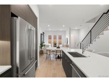 Modern kitchen with stainless steel appliances and an island that overlooks the dining area at 1815 N Williams St, Denver, CO 80218