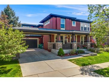 Charming two-story home featuring a covered porch, attached garage, and well-maintained landscaping at 13324 W 86Th Dr, Arvada, CO 80005