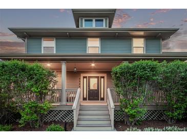 Charming home featuring a covered front porch, a well-manicured lawn, and classic architectural details at 2345 Akron St, Denver, CO 80238