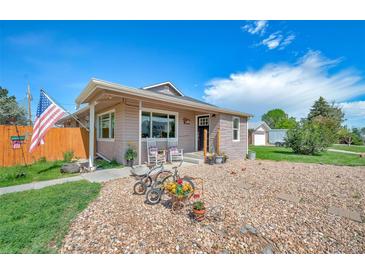 Charming home featuring a quaint porch and delightful decorative bicycle accents in the front yard at 1775 Longbranch St, Strasburg, CO 80136