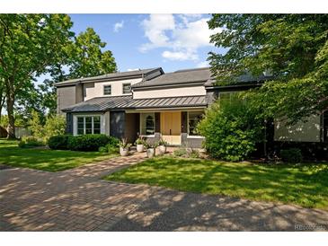 Inviting home exterior with a brick pathway and landscaped yard leading to the front door at 1 Sedgwick Dr, Cherry Hills Village, CO 80113