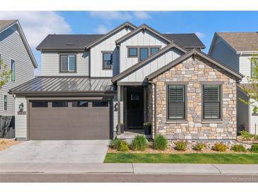Beautiful two-story home with stone and siding, a well-manicured lawn and a two car garage at 11103 Cloud Shadow St, Littleton, CO 80125