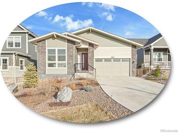 Charming single-Gathering home featuring a well-maintained lawn, a two-car garage, and stone detailing at 8894 River Peak Cir, Littleton, CO 80125