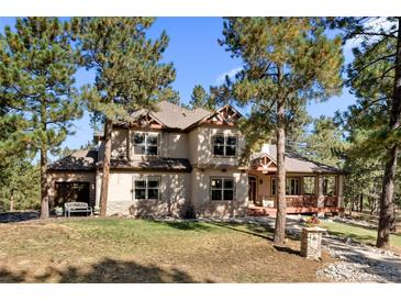 Beautiful two-story home with a manicured lawn and mature trees offering a serene and private setting at 7737 Taylor Cir, Larkspur, CO 80118