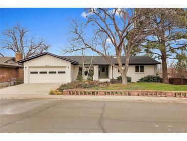 Charming single-story home featuring a two-car garage, a landscaped yard, and a brick retaining wall at 2961 S Rosemary St, Denver, CO 80231