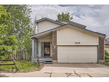 Charming two-story home with a front porch and an attached garage at 7198 Eaton Ct, Arvada, CO 80003