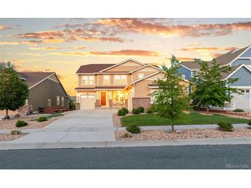 Charming two-story home boasts a well-manicured lawn and a welcoming entrance, perfect for Gathering living at 19894 W 94Th Ln, Arvada, CO 80007
