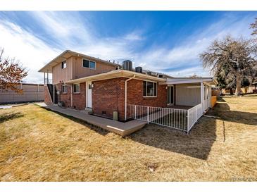 Spacious backyard featuring a brick house with a covered patio and a well-maintained lawn at 3611 W 79Th Ave # B4, Westminster, CO 80030