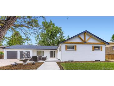 Charming exterior with white brick, modern dark trim, 2 car garage and inviting front patio at 6537 Everett St, Arvada, CO 80004