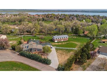 Expansive property featuring a main house, additional building, and large yard with views of the lake at 8280 Queen St, Arvada, CO 80005